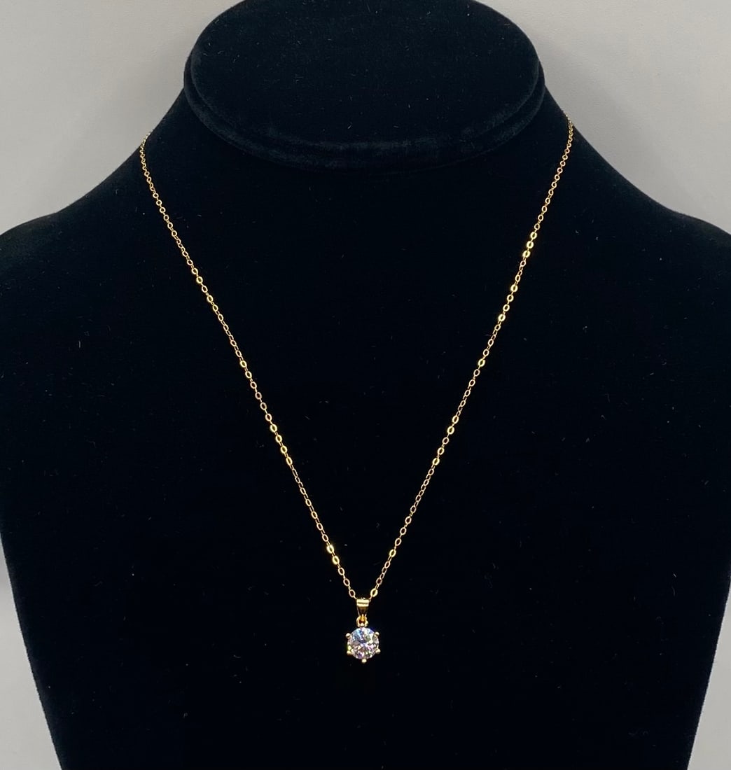 Round Brilliant Solitaire Moissanite Pendant Necklace 18K Gold: 1 CT Round Brilliant Solitaire Moissanite Pendant Necklace 18K Gold. Material: 18K Yellow Gold plated over premium Sterling Silver Gemstone: Genuine Clear Moissanite (Passes as diamond on standard