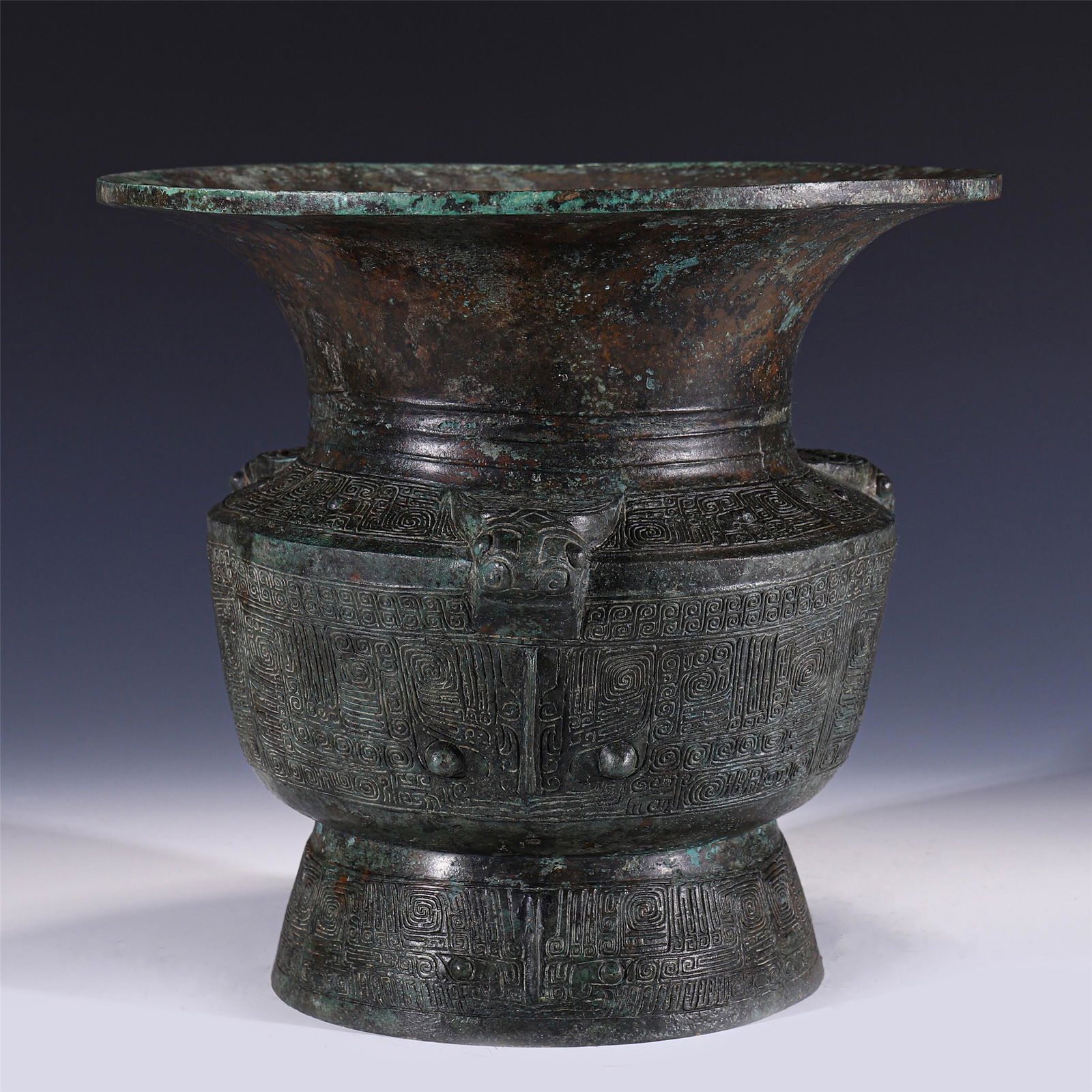 BRONZE ZUN VASE: A CHINESE BRONZE ZUN VASE 28.7 cm H x 31.5 cm Diam x Weight 1280 gram. Zun with round abdomen, circle feet outside. Abdominal swirl pattern, three cow heads appear on the shoulders of the organs. The
