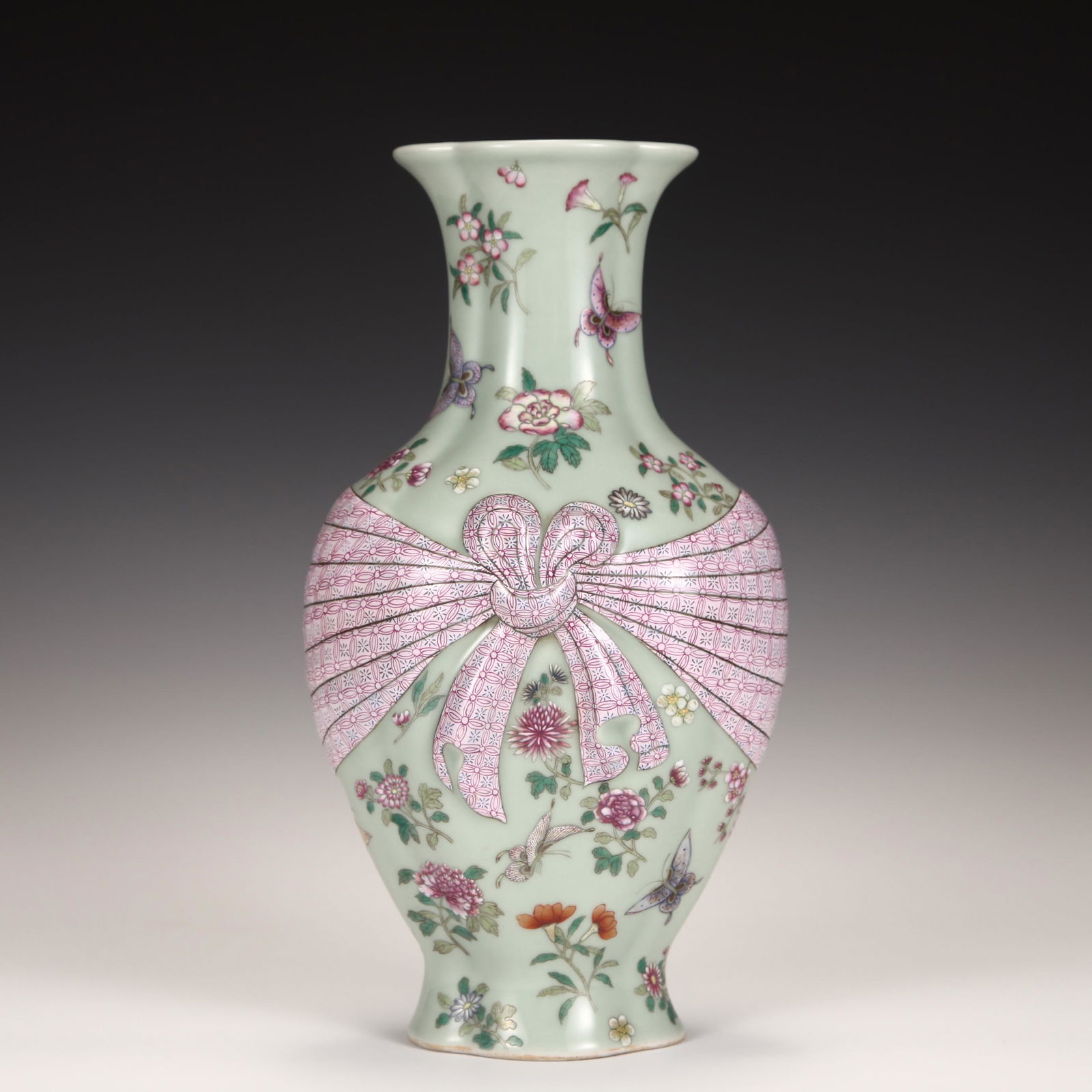 A CHINESE FAMILLE ROSE PORCELAIN VASE: A CHINESE FAMILLE ROSE PORCELAIN VASE 30 cm H x 17.5 cm W The pink flower butterfly lace up bottle has a curly mouth, a neck and shoulders, a round belly and a circle of feet at the bottom. The shape