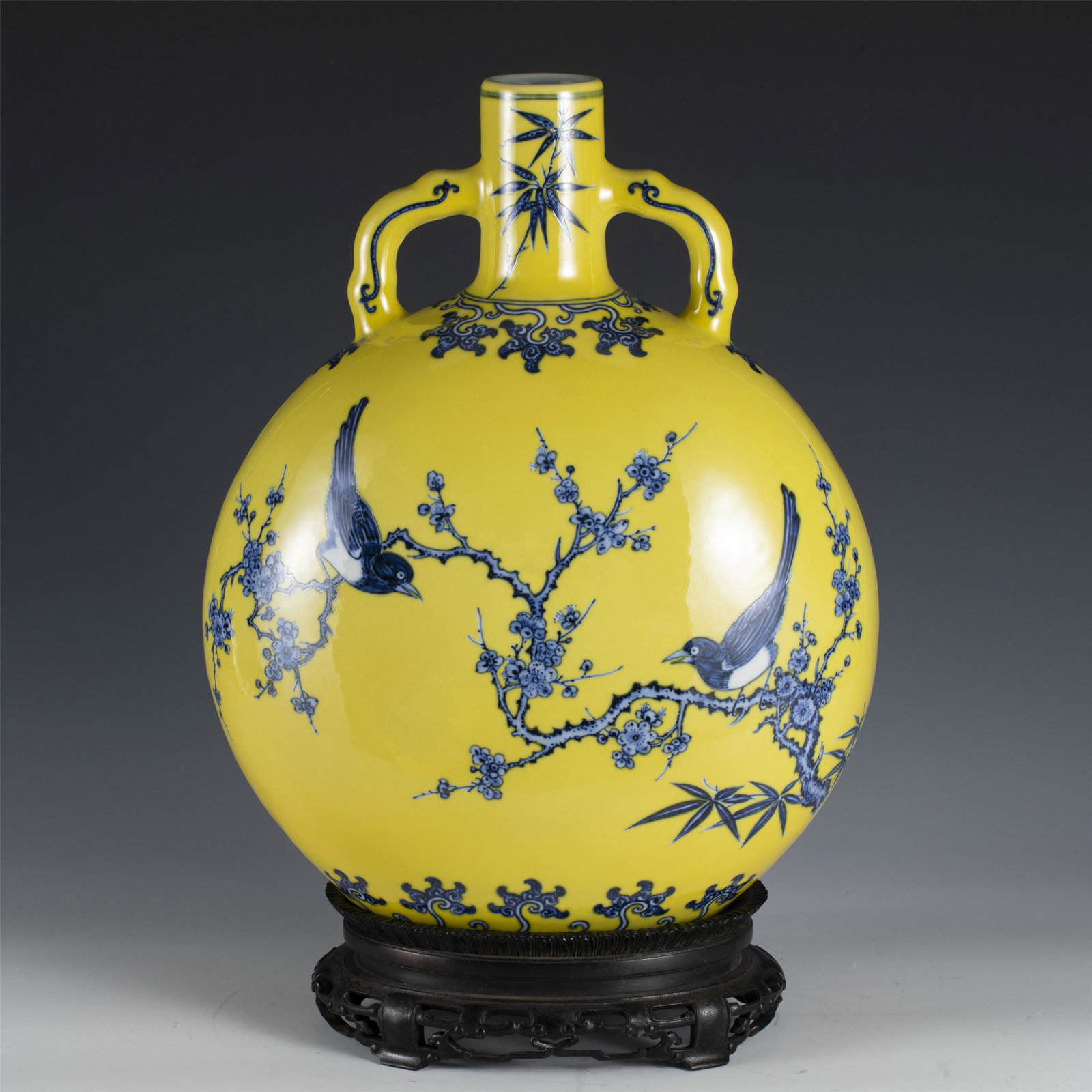 A YELLOW GLAZE BLUE AND WHITE PORCELAIN FLASK MOON VASE,QING: A YELLOW GLAZE BLUE AND WHITE PORCELAIN FLASK MOON VASE,QING 26 cm L x 13 cm W x 36.5 cm H x Weight 4720 gram. The flattened globular body rising from a short oval foot to a slender neck flanked by a 
