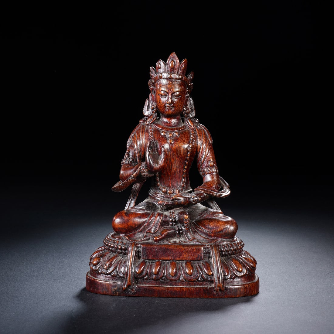 CHINESE HUANGHUALI BODHISATTVA STATUE: Dimensions:11x7x15.5 cm. A fine Chinese Qing dynasty seated Bodhisattva statue carved from huanghuali (yellow pear wood), depicted in the lotus position with one hand raised in vitarka mudra and