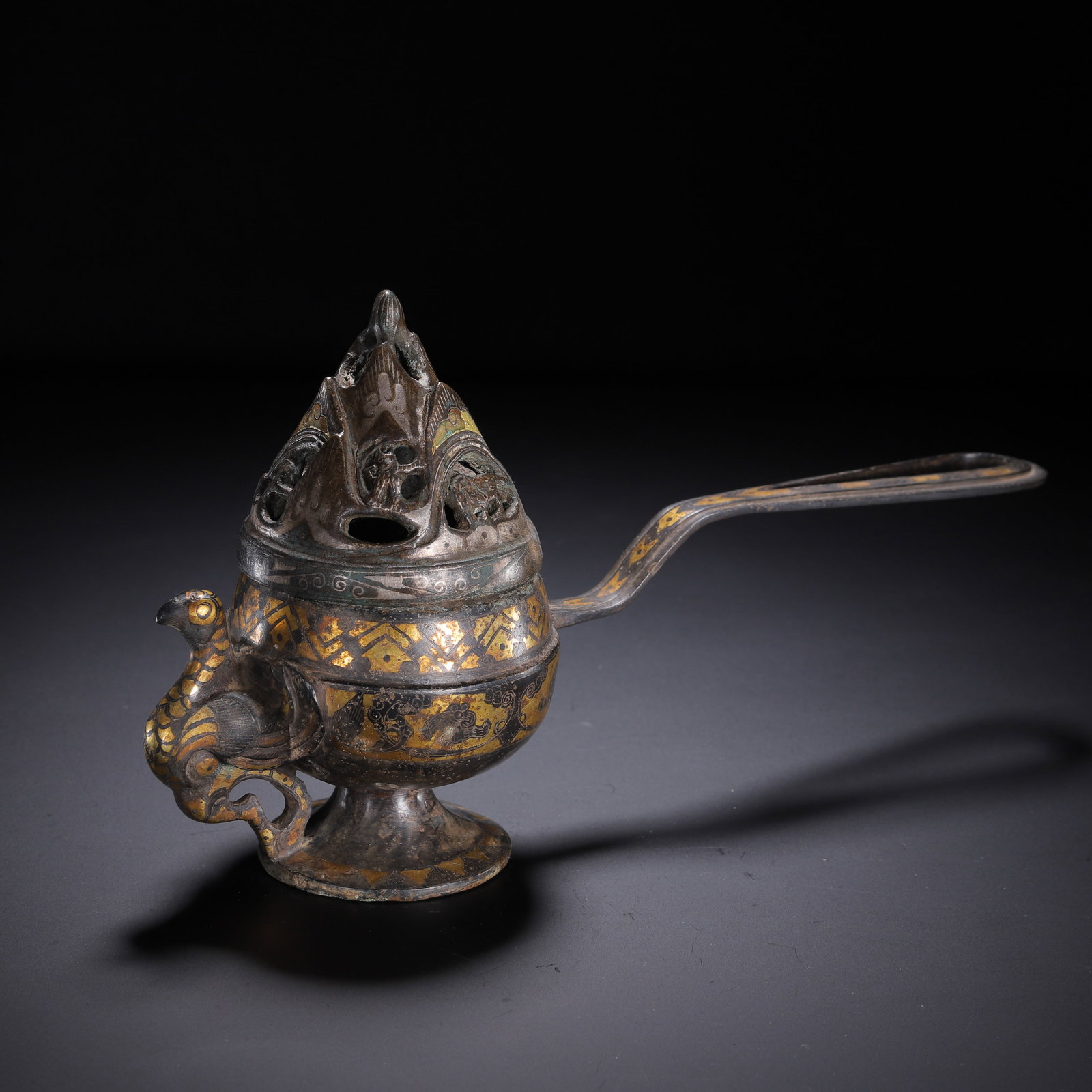 CHINESE GILDED BRONZE BOSHAN CENSER: Dimensions:L. 25 cm. W. 8 cm. H. 15 cm. Weight 720 grams. A Chinese gilded bronze boshan censer, designed with a mountain-form pierced lid for smoke diffusion, a long curved handle, and a