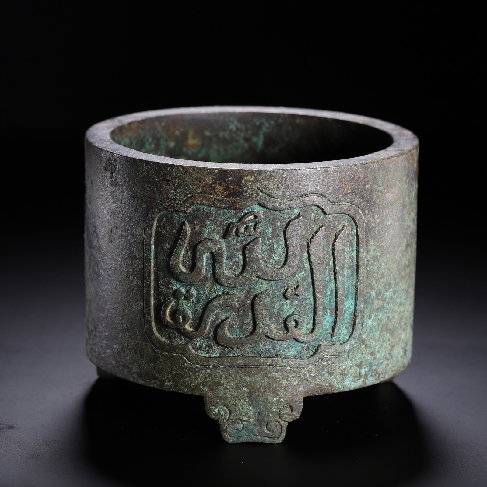 CHINESE BRONZE CENSER WITH ARABIC INSCRIPTION: Dimensions:L. 12.5W. 12.5H. 12 cm. Weight 2050 grams. A fine Chinese cylindrical bronze censer, supported by three elegantly shaped feet with scroll detailing. The body is adorned with a prominent