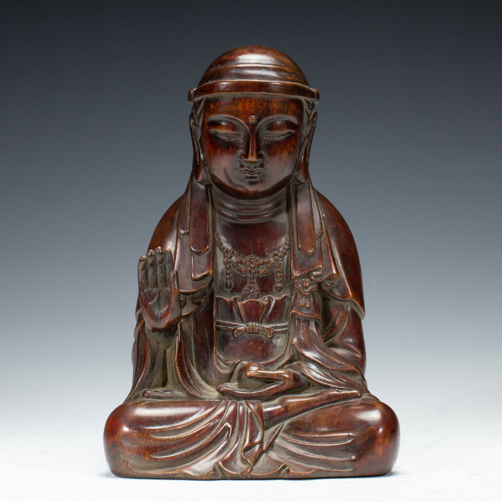 CHINESE AGARWOOD BODHISATTVA FIGURE: Dimensions:L. 15.5 cm. W. 13 cm. H. 22.5 cm. Weight 570 grams. A fine Chinese seated Bodhisattva figure carved from agarwood, depicted in a serene meditative pose with one hand raised in abhaya mudra 