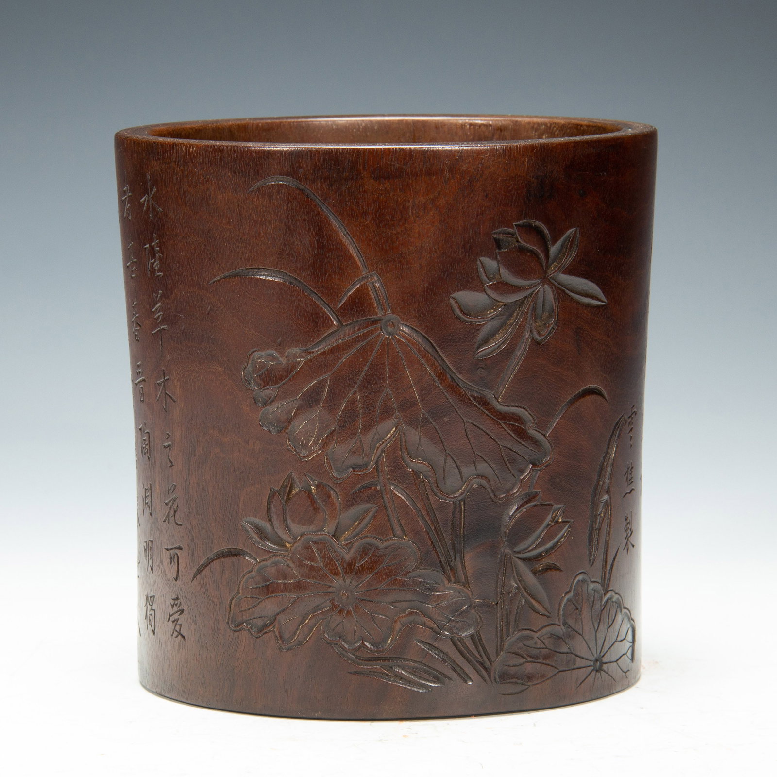 A CHINESE HUANGHUALI LOTUS BRUSH POT: Dimensions:L. 14 cm. W. 14 cm. H. 15.5 cm. Weight 600 grams. A cylindrical brush pot carved from precious huanghuali (yellow pear wood), showcasing deep relief carvings of lotus flowers, leaves,