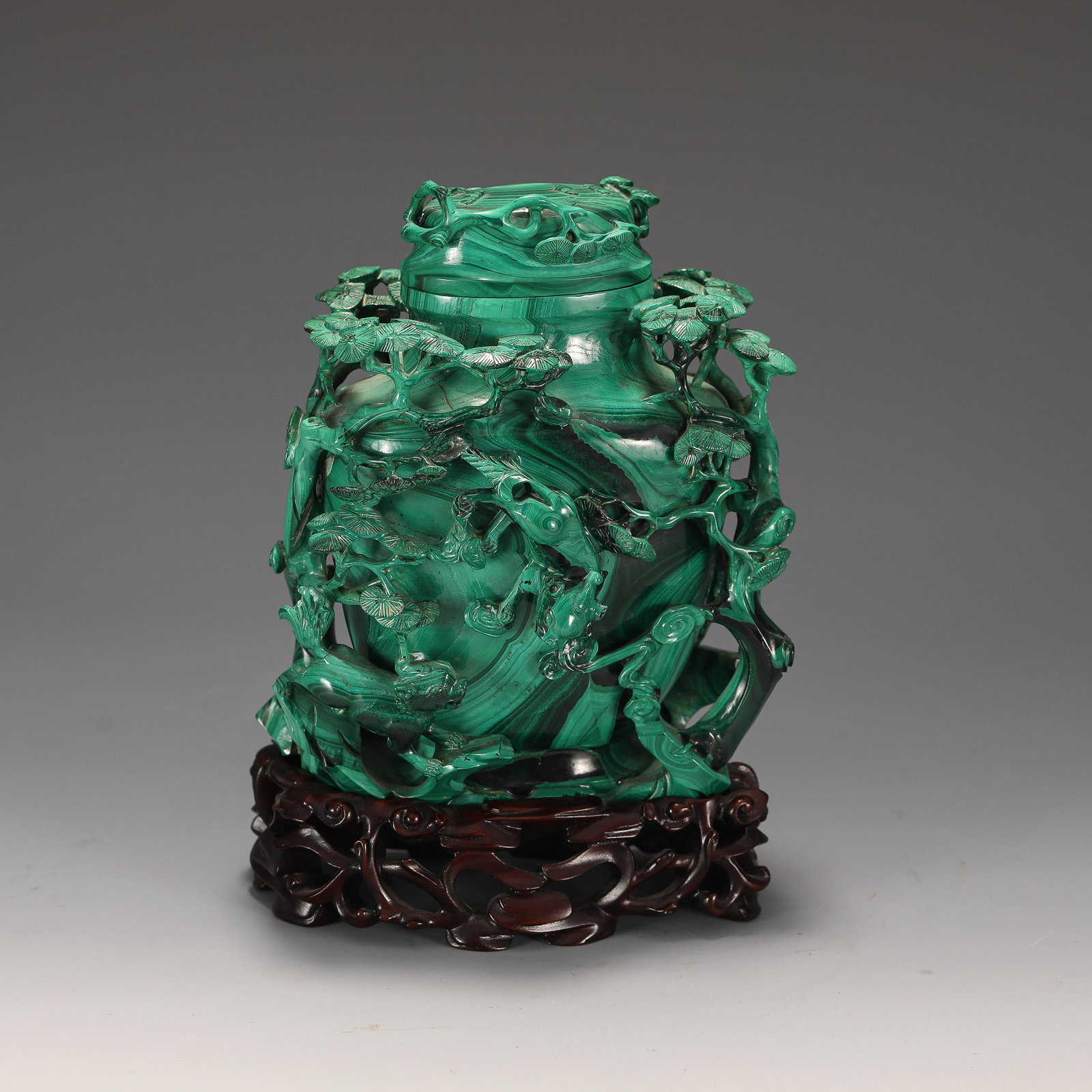 A CHINESE MALACHITE BEAST-HANDLED VASE: Dimensions:L. 13 cm. W. 9 cm. H. 19 cm. Weight 1825 grams. This striking Chinese vase is masterfully carved from vibrant banded malachite, showcasing the stone’s iconic swirling green