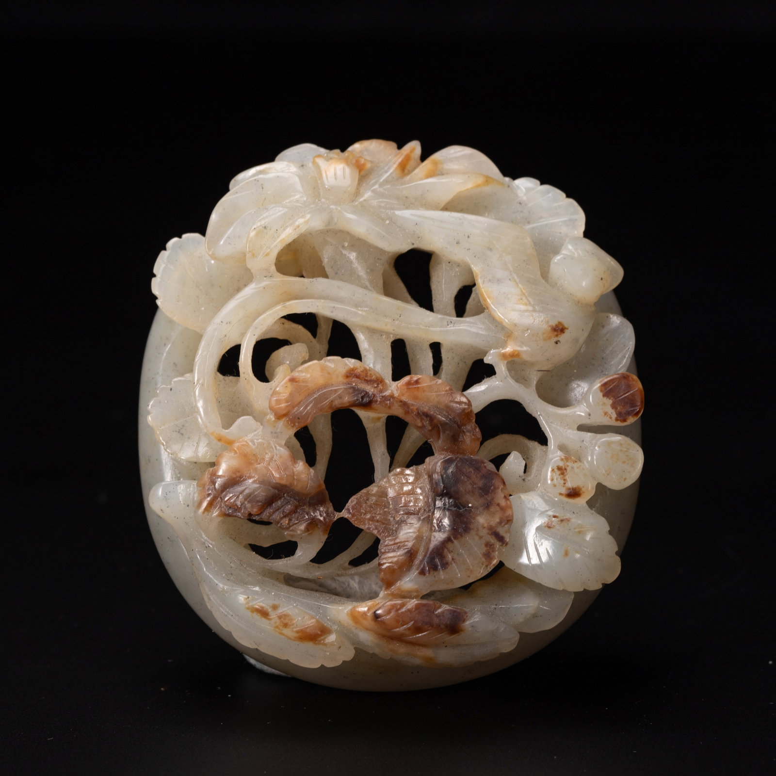 CHINESE HETIAN JADE FLORAL PLAQUE: Dimensions:L. 6 cm. W. 5.5 cm. Weight 70 grams. A Chinese Hetian jade floral plaque, carved from pale celadon jade with natural russet inclusions skillfully integrated into the design. It features ope