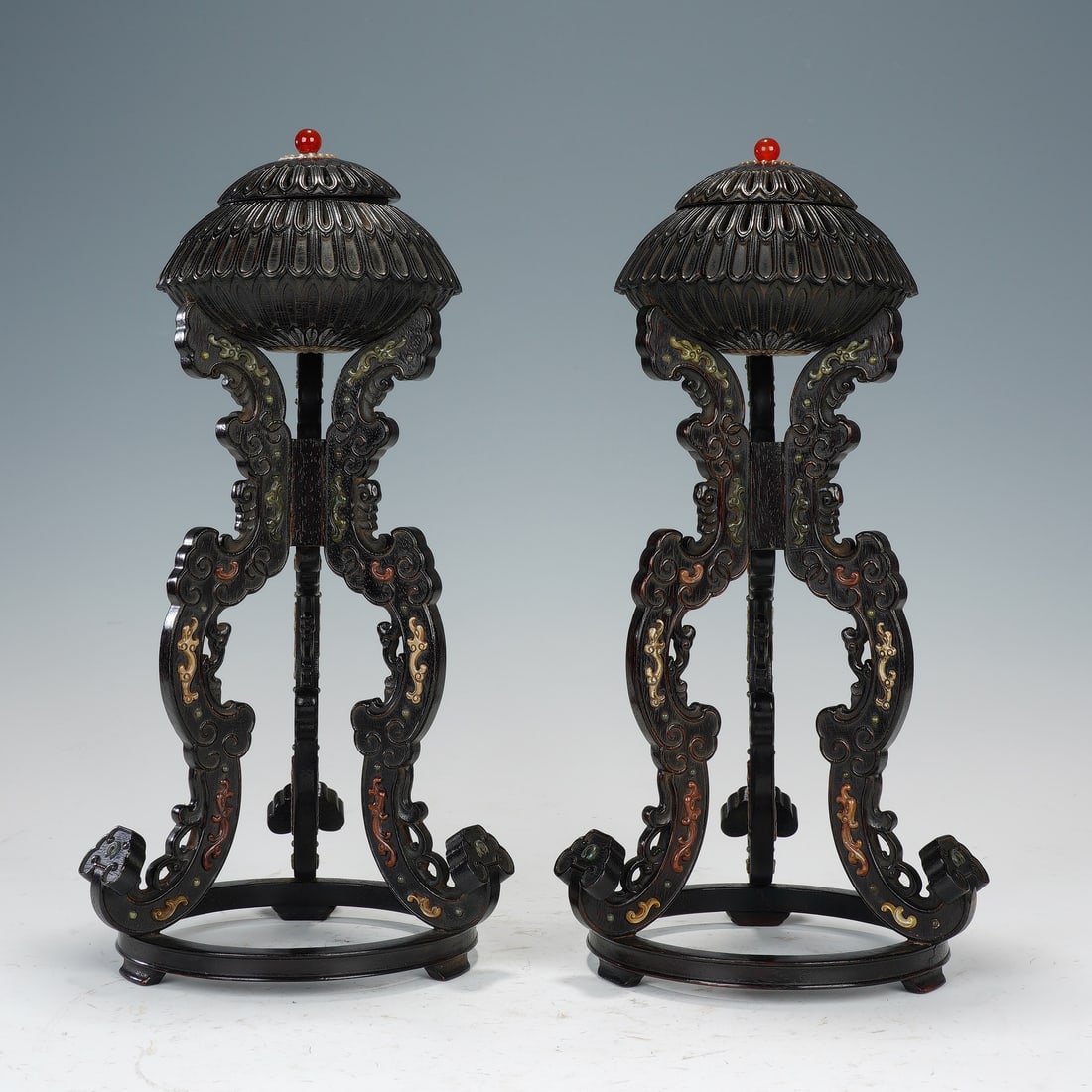 A PAIR OF CHINESE ZITAN HAT STANDS: Dimensions:15x32 cm. This is a refined pair of Qing dynasty Chinese hat stands crafted from precious zitan wood. Each stand features an ornate lotus-shaped top crowned with a red bead, supported