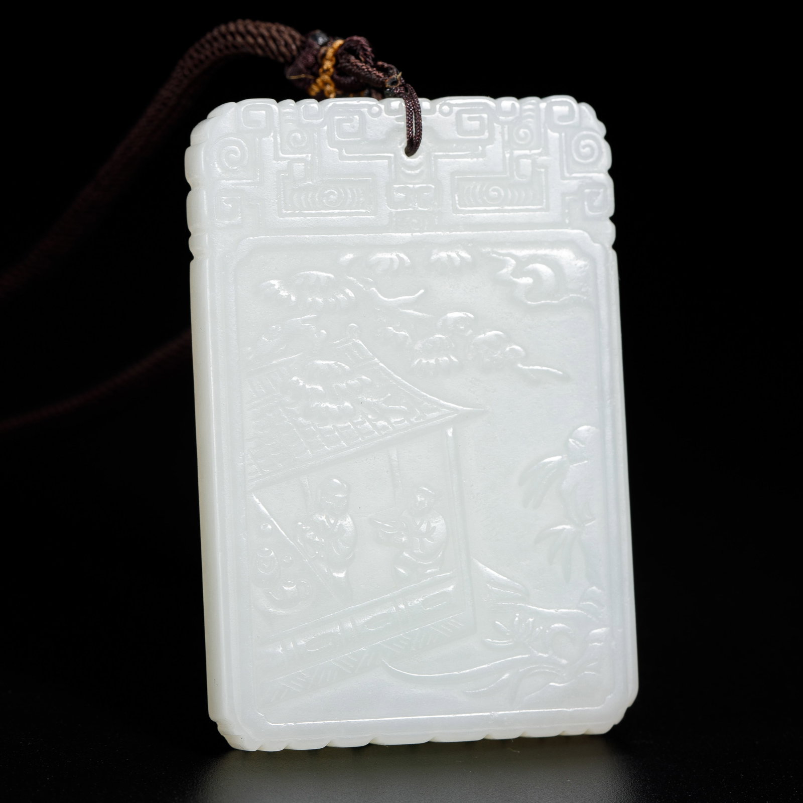 A CHINESE HETIAN JADE FIGURAL PLAQUE: Dimensions:L. 4 cm. W. 0.7 cm. H. 6 cm. Weight 49 grams. This refined Chinese plaque is masterfully carved from luminous white Hetian jade, featuring a rectangular form with a decorative geometric