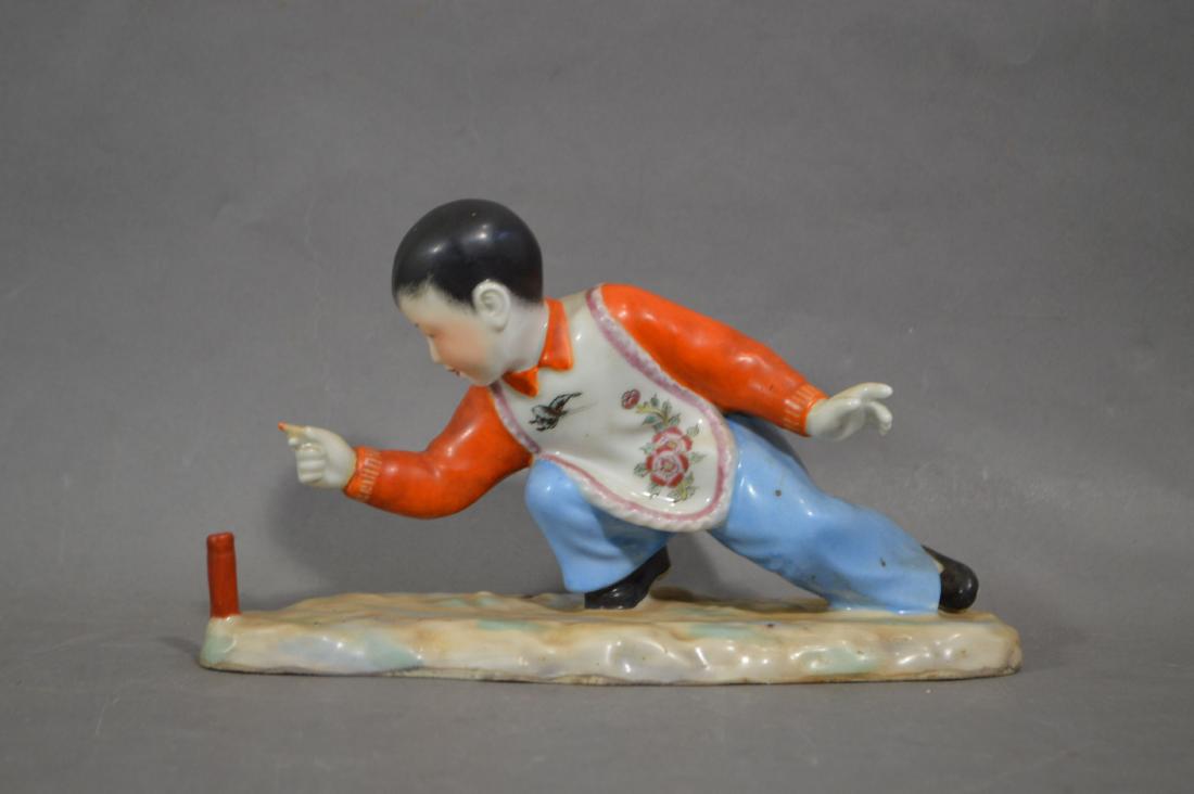 FAMILLE ROSE CULTURAL REVOLUTION FIGURE OF A BOY: FAMILLE ROSE CULTURAL REVOLUTION FIGURE OF A BOY LIGHTING A FIRECRACKER 9.5"L, 5.5" T