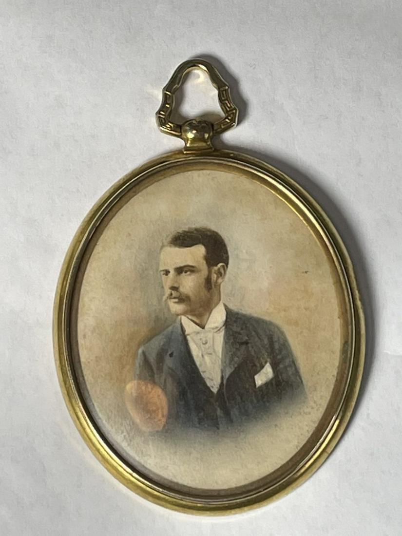 A GILT EDWARDIAN PENDANT WITH A HAND COLORED PORTRAIT: A GILT EDWARDIAN PENDANT WITH A HAND COLORED PORTRAIT 3" X 2"