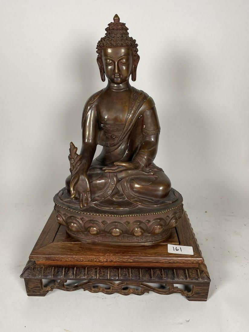 A BRONZE BUDDHA WITH MARK ON BOTTOM WITH WOODEN STAND: A BRONZE BUDDHA WITH MARK ON BOTTOM WITH WOODEN STAND 15" X 9.5" X 6". WEIGHS 6 LBS 10 OZ TOTAL