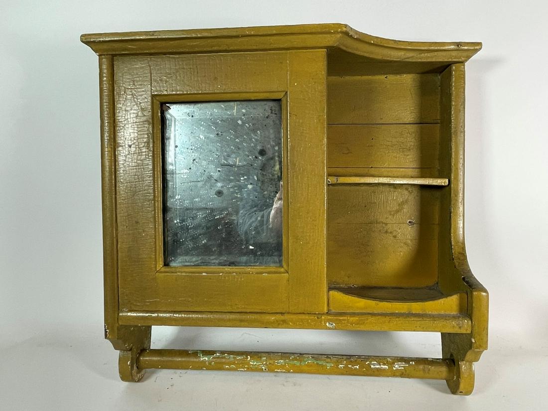 A 19TH CENTURY MIRRORED SHELF WITH TOWEL RACK IN OLD: A 19TH CENTURY MIRRORED SHELF WITH TOWEL RACK IN OLD MUSTARD PAINT 17" X 16" X 5"