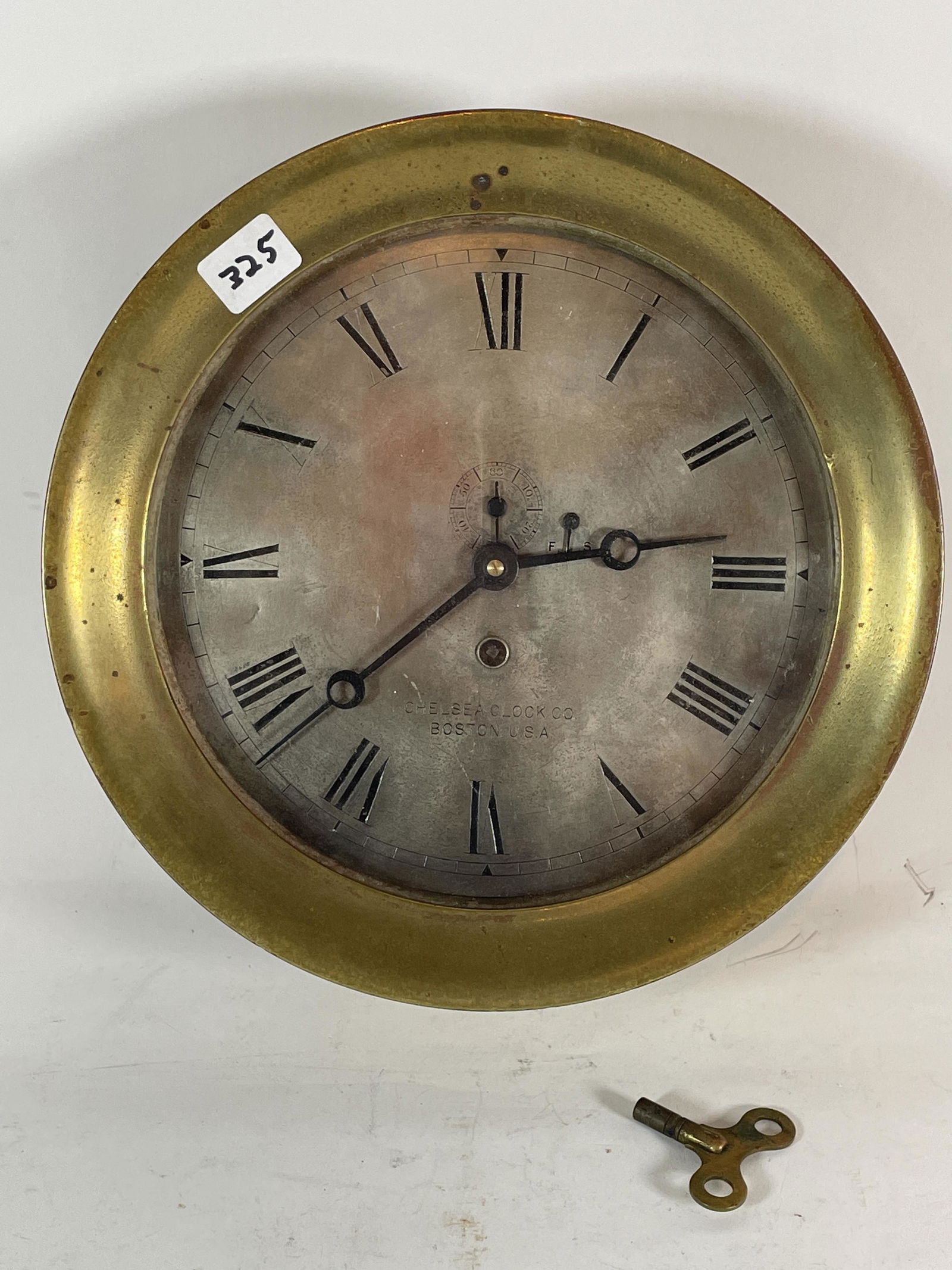 AN ANTIQUE 10" DIAMETER CHELSEA SHIPS CLOCK. WITH KEY (1 of 8)