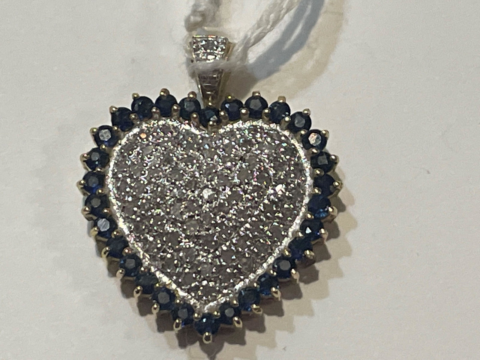 A 14K GOLD HEART SHAPED PENDANT WITH DIAMONDS 1" X: A 14K GOLD HEART SHAPED PENDANT WITH DIAMONDS 1" X .85". 3.9 GRAMS