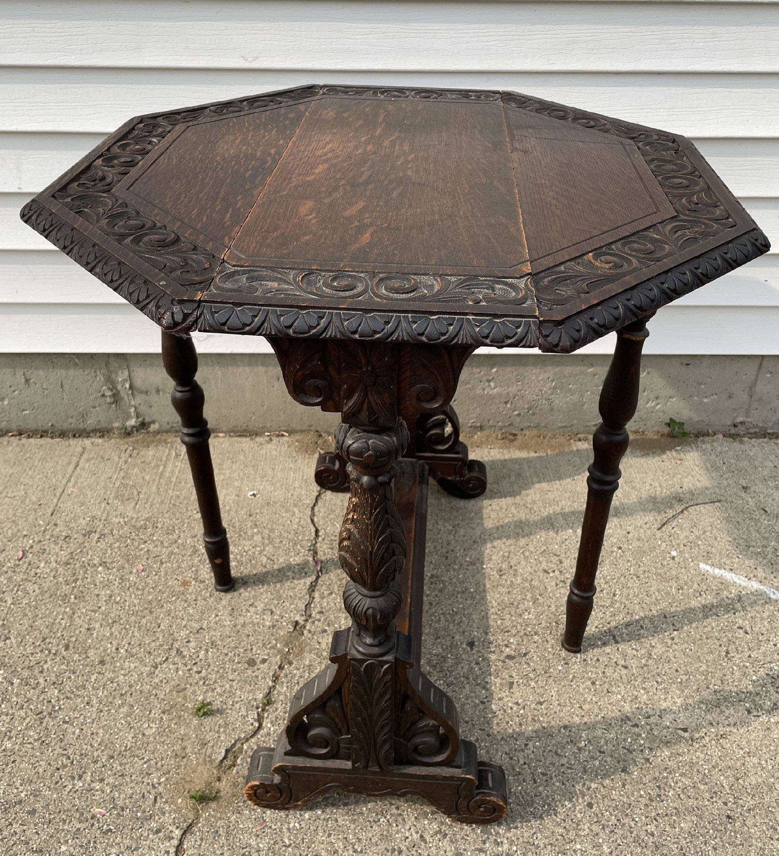 A CARVED OAK CONTINENTAL TUCK TABLE, 28" X 10" X 28", 9" LEAVES: A CARVED OAK CONTINENTAL TUCK TABLE, 28" X 10" X 28", 9" LEAVES