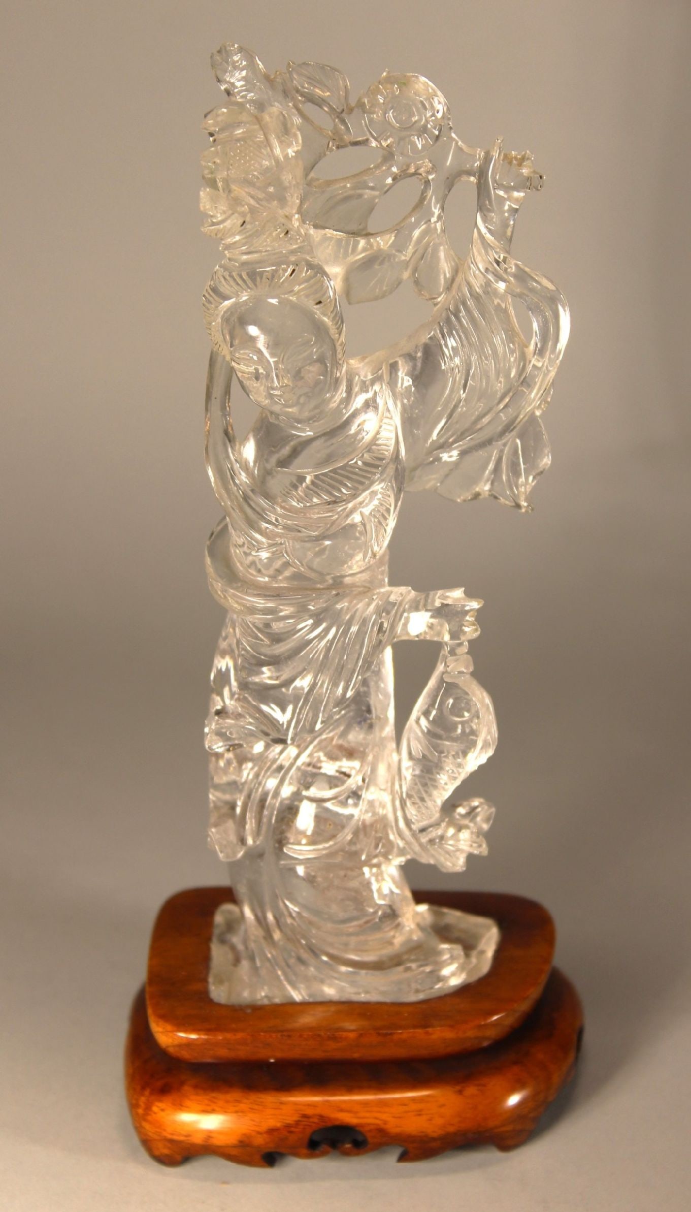 ROCK CRYSTAL CHINESE CARVED DEITY FIGURE W/ FISH ON TEAK BASE, 8": ROCK CRYSTAL CHINESE CARVED DEITY FIGURE W/ FISH ON TEAK BASE, 8"