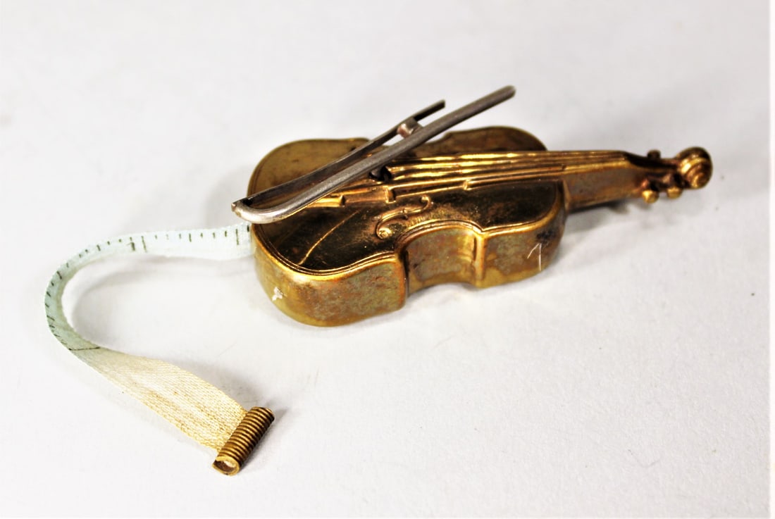 ANTIQUE BRASS MEASURING TAPE IN THE FORM OF A VIOLIN, WORKING CONDITION. 2.75" (1 of 2)
