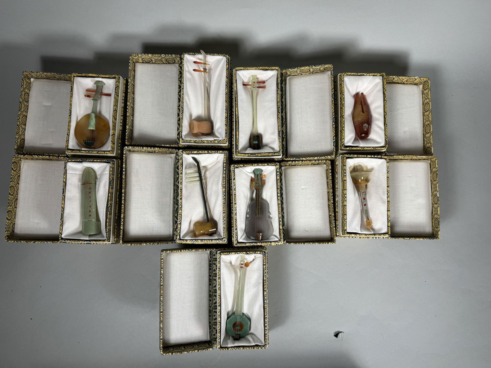 A COLLECTION OF 9 CARVED HARDSTONE INSTRUMENTS IN DECORATIVE BOXES, 5" AND SMALLER: A COLLECTION OF 9 CARVED HARDSTONE INSTRUMENTS IN DECORATIVE BOXES, 5" AND SMALLER