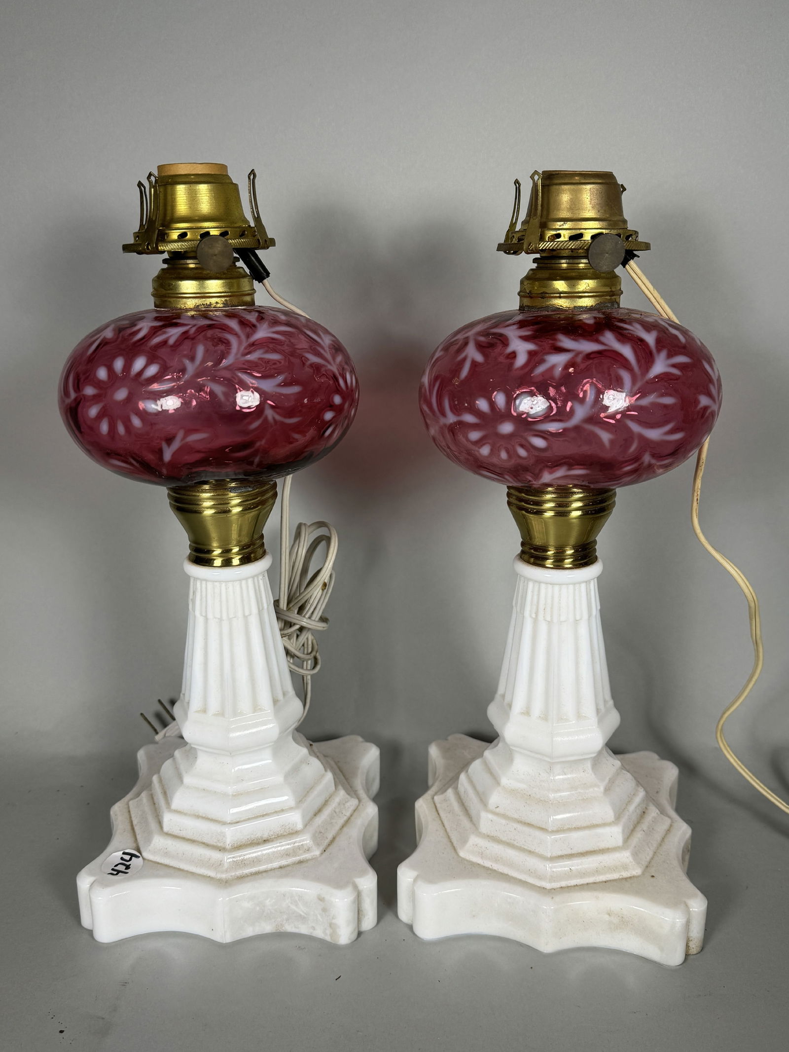 A PAIR OF CRANBERRY AND MILK GLASS OIL LAMPS CONVERTED TO ELECTRIC, 14" EACH (1 of 6)