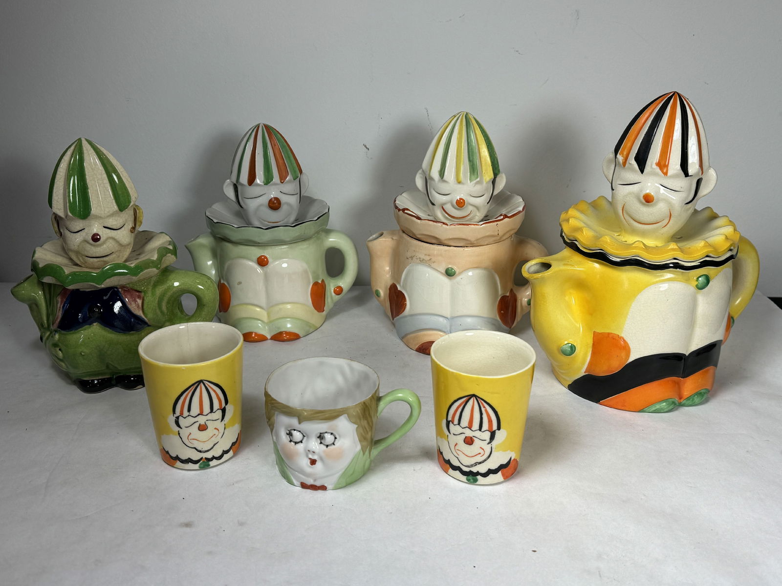 FOUR VINTAGE CARNIVAL CLOWN JUICERS W/ THREE CUPS, 9.5" X 8.5" AND SMALLER. SOME CRAZING AND PAINT (1 of 12)