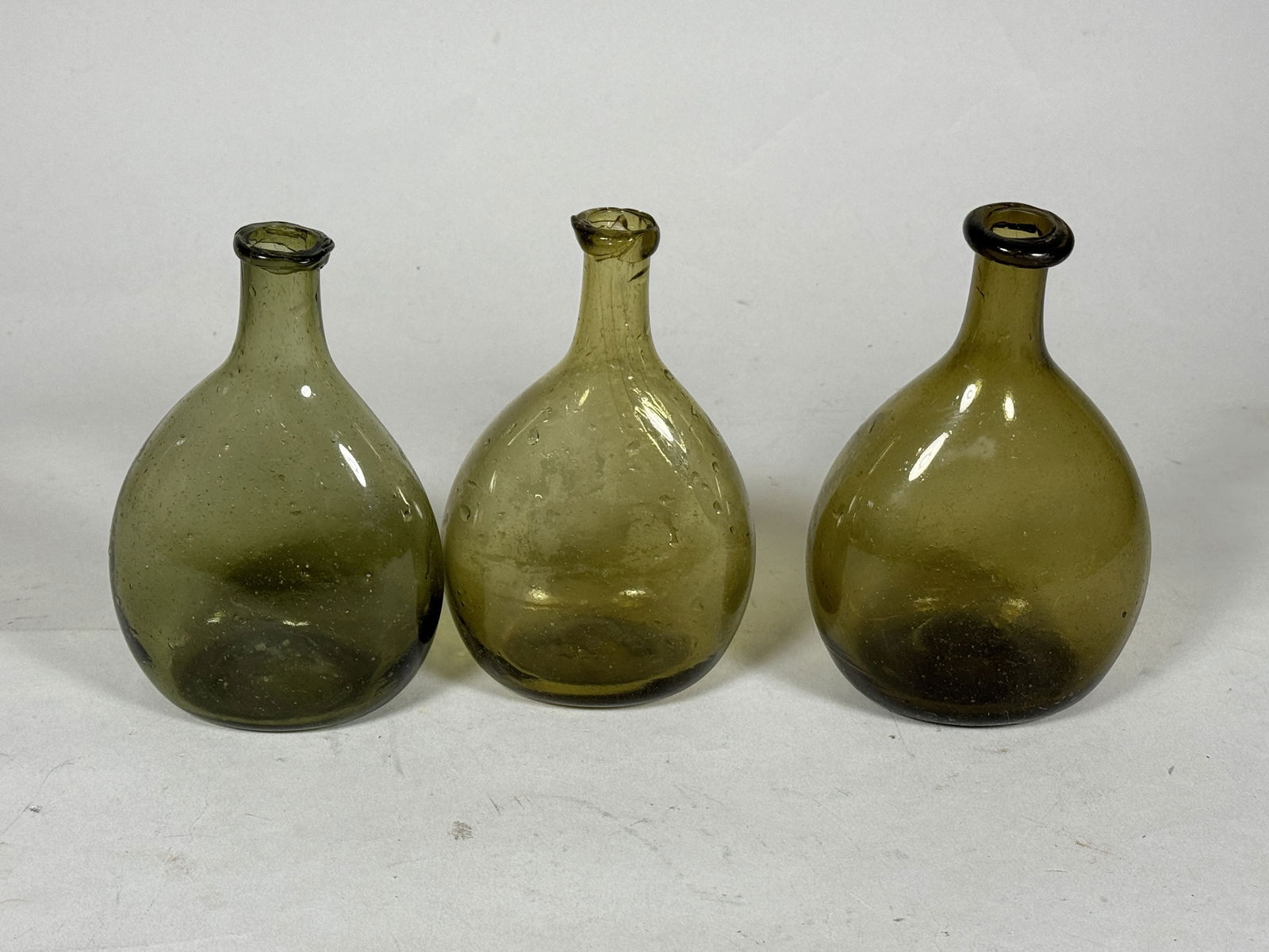 THREE EARLY OLIVE GREEN FLASKS: THREE EARLY OLIVE GREEN FLASKS