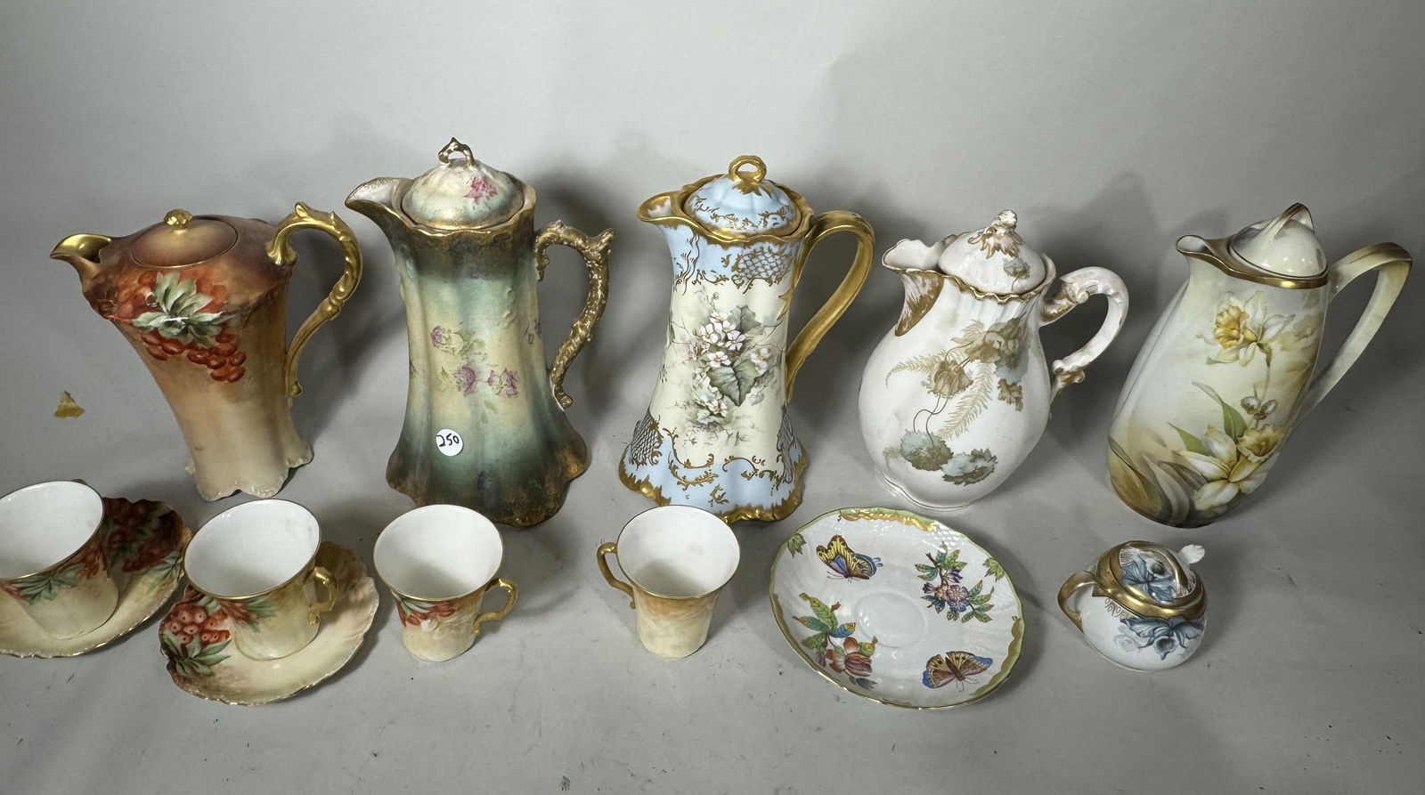 A COLLECTION OF TEN CHOCOLATE POTS WITH CUPS AND SAUCERS (1 of 8)