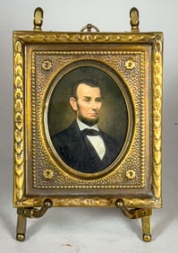 A PORTRAIT MINIATURE OF ABRAHAM LINCOLN IN BRASS FRAME/EASEL