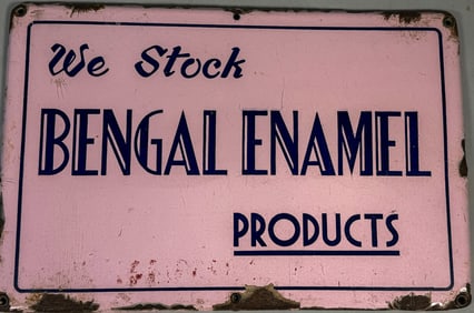 A PINK ENAMELED ADVERTISING SIGN, 18" X 12"