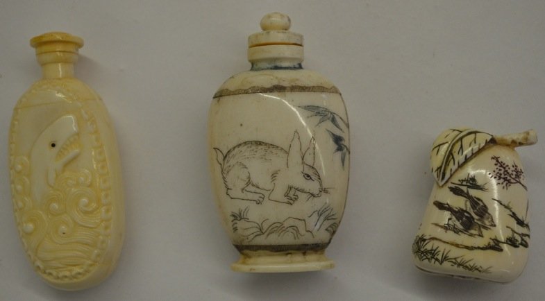 2 IVORY SNUFF BOTTLES AND IVORY FRUIT WITH EROTIC SCENE: 2 IVORY SNUFF BOTTLES- ONE WITH A SHARK, ONE WITH A DOG AND RABBIT/ EACH 3" HEIGHT. AND A 2 PC. IVORY CARVING OF FRUIT THAT OPENS UP TO AN EROTIC SCENE. 1 ½" HEIGHT.