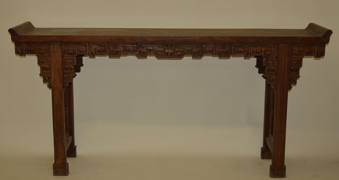 Chinese Qing Huanghuali Altar Table, Qing dynasty.: Huanghuali wood altar table, Qing Dynasty, the long able top carved out of one piece of wood, the spandrels carved with clouds pattern and with reverted scroll form ends. 33 1/2" x 15" x 72"