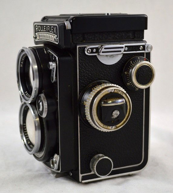 Rolleiflex Camera, with Accessories: Rolleiflex Camera with original box, leather case and 2.8 Planar Zeiss Lens. Also includes various filters and accessories. Serial Number 1665294. Measures 5.5'' x 3'' x 3''. Very good condition.