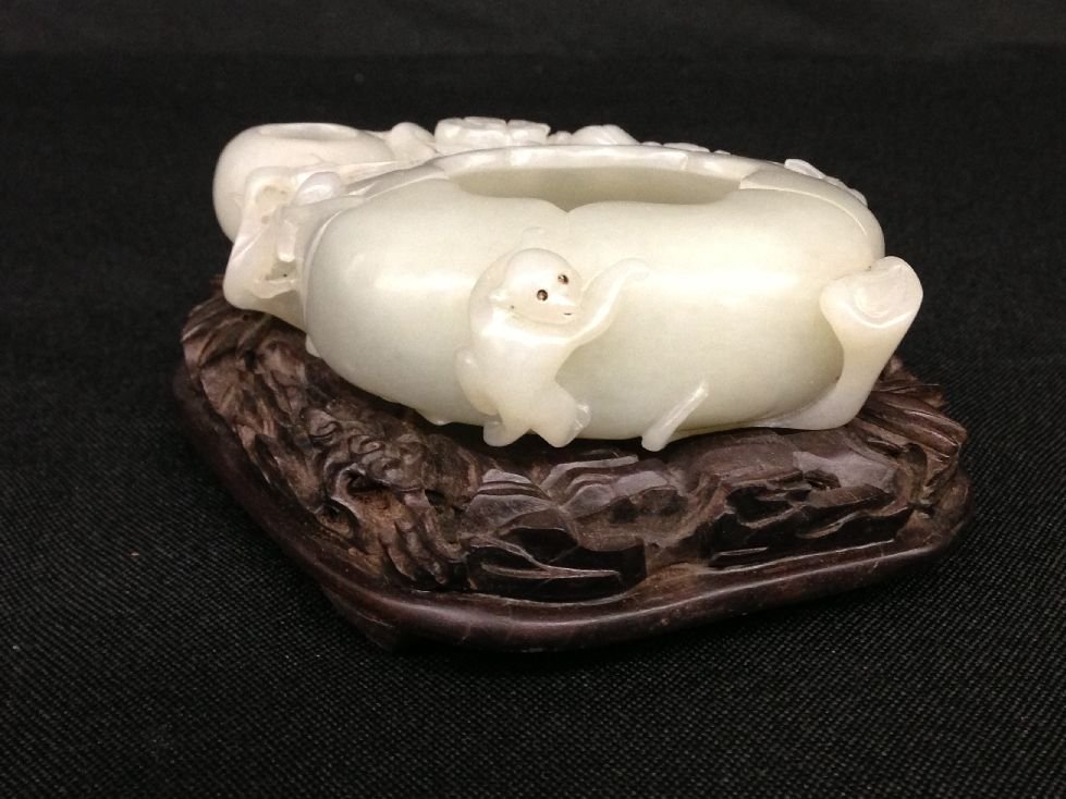 Delicate Carved White Jade Brush Washer: Jade Brush washer, China, 18c, peach shaped brush washer with carved monkey, Gilt Qing Qianlong mark on base, with hardwood stand. 7/8” x 4” x 3 1/8”
