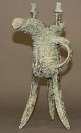 Chinese Antique Bronze Wine Cup: Antique bronze wine cup, China, on tripod feet, decorated with complex patterns on body. 12 1/2"