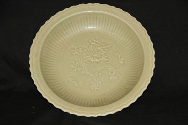 Green Glazed Porcelain Plate: Green glazed porcelain plate, China, Ming Dynasty. Decorated with a flying dragon amist flames and clouds in the center. 13" X 3"