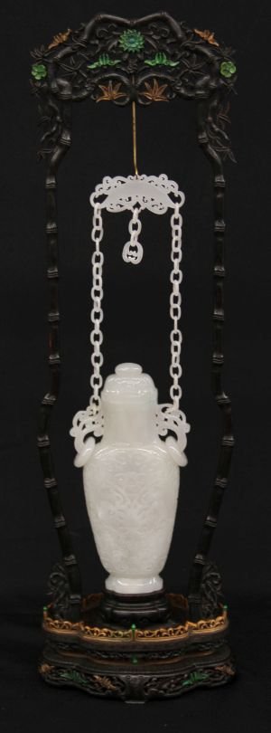 Carved White Jade Chain Vase: Rare and fine carved white jade vase, two handles with loose rings, with a long chain,decorated with incised floral patterns on body, on a carved hardwood stand. 9" w/lid; 17" w/chain; 24" w/stand