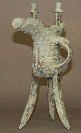 Chinese Antique Bronze Wine Cup: Antique bronze wine cup, China, on tripod feet, decorated with complex patterns on body. 12 1/2"