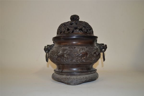 Bronze Censer: Bronze censer, China, two animal head shaped handles with loose rings, decorated with openwork and flying dragons amist clouds on cover and carved waves on body, Xuande mark on base.9 1/2" X 9 1/2"