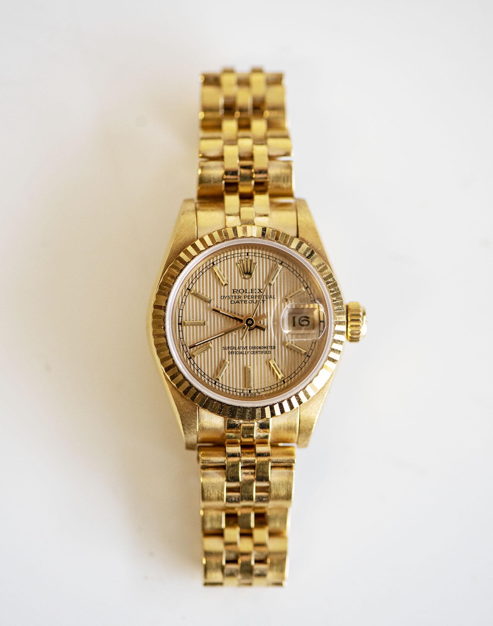 A LADYÃ¢â‚¬â„¢S GOLD WRISTWATCH, ROLEX OYSTER PERPETUAL: A LADYÃ¢€â„¢S GOLD WRISTWATCH, ROLEX OYSTER PERPETUAL the circular gold dial with baton hour markers, calibrated outer ring, sweeping seconds hand, date aperture at 3 oÃ¢€â„¢cloc