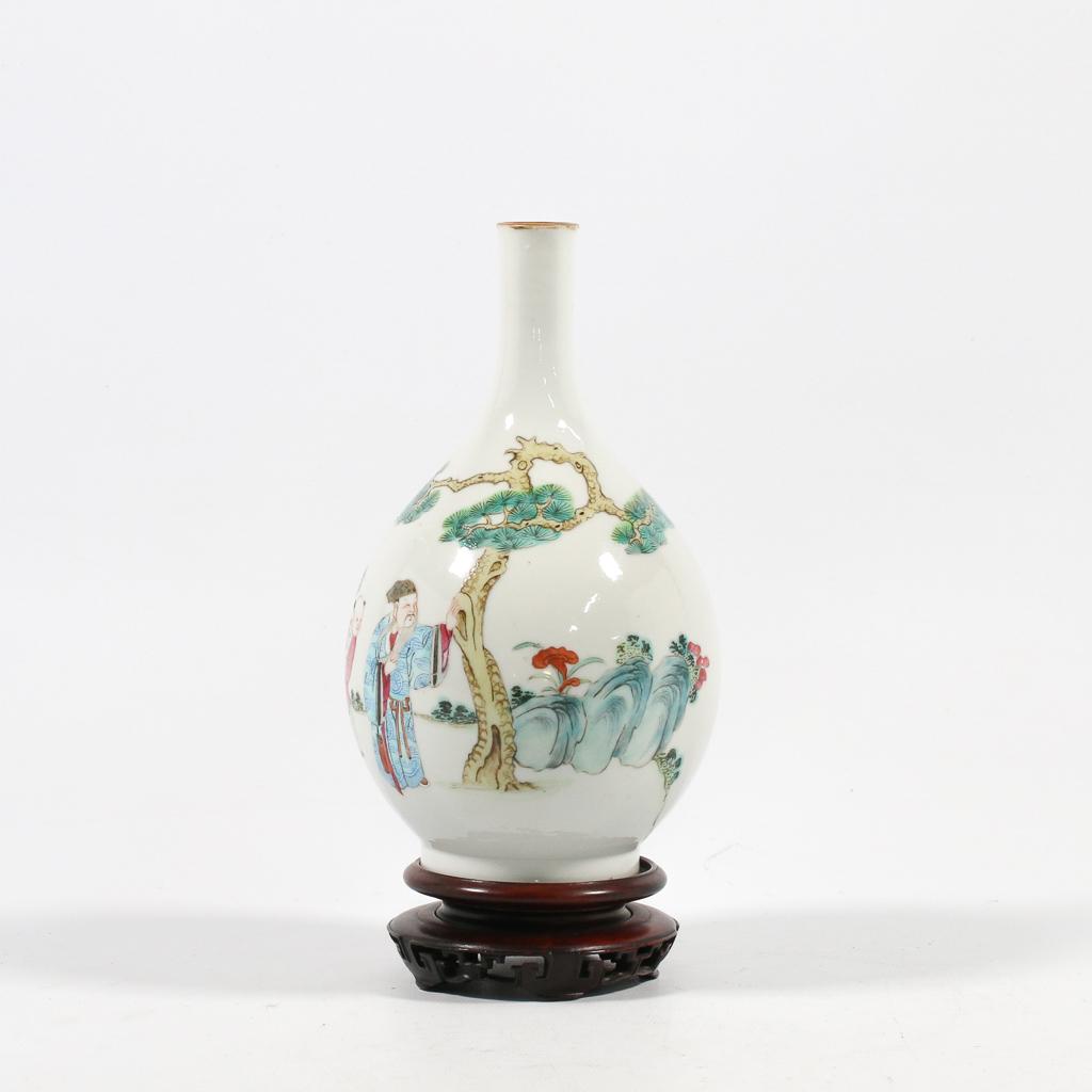 A vase made of Chinese porcelain and decorated with: A vase made of Chinese porcelain and decorated with pine trees and wise men. 19th century. Condition: Hairline neck. (18 x 11 cm)