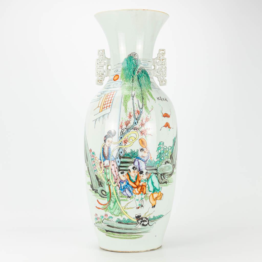 A vase made of Chinese porcelain, decorated with: A vase made of Chinese porcelain, decorated with ladies, children and a cat. 19th/20th century. (59 x 23 cm)