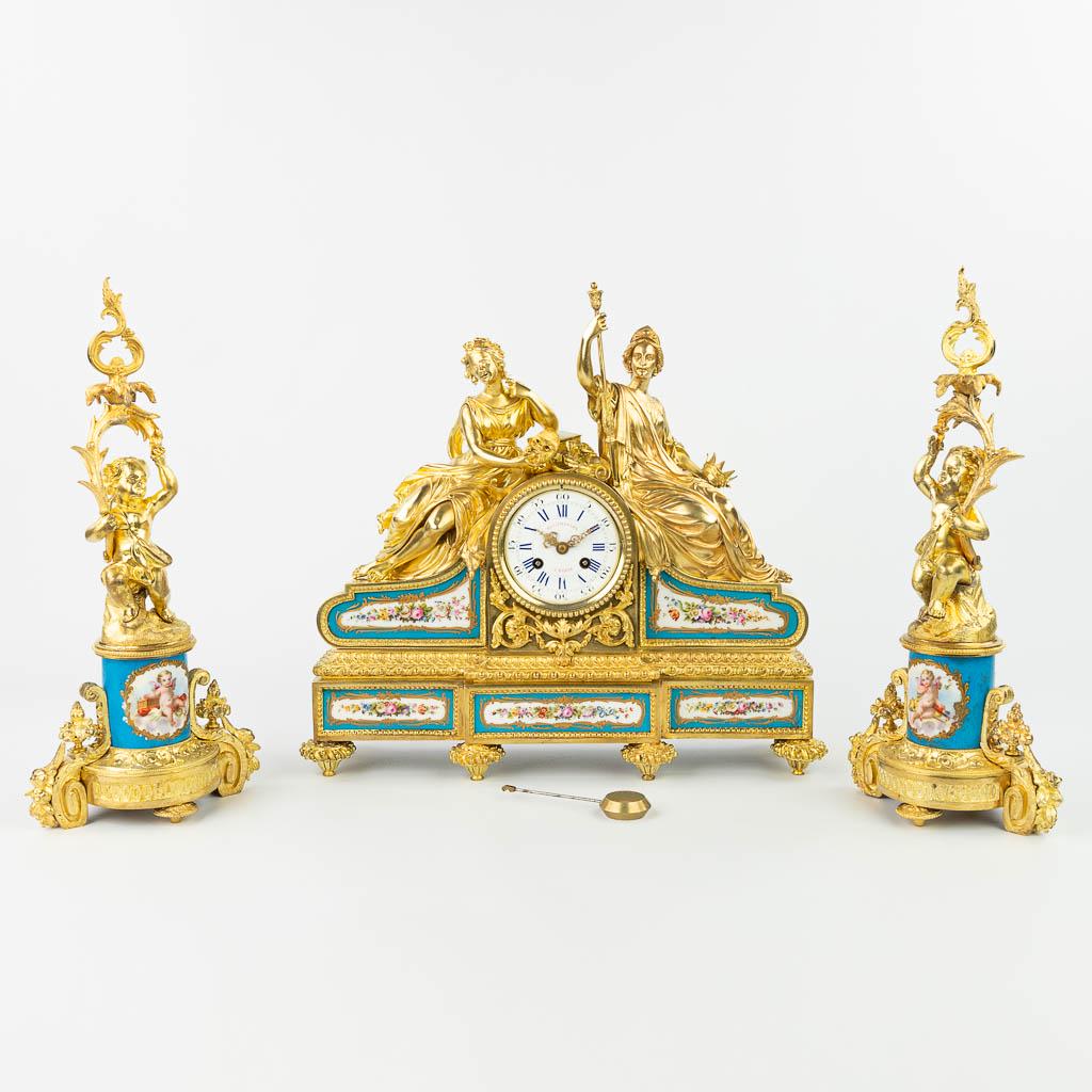 A three-piece garniture clock with candelabra, made of: A three-piece garniture clock with candelabra, made of gilt bronze and decorated with sÃ¨vres plaques. Marked Balthazard, made in France. 19th century. Height candelabra: 41 cm. (12 x 44 x 40,5 cm)