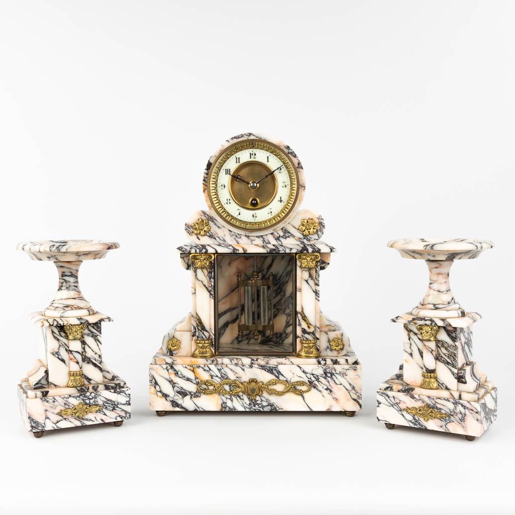 A three-piece garniture clock and side pieces, made of white and gray marble. Circa 1900. (L: 12 x (1 of 12)