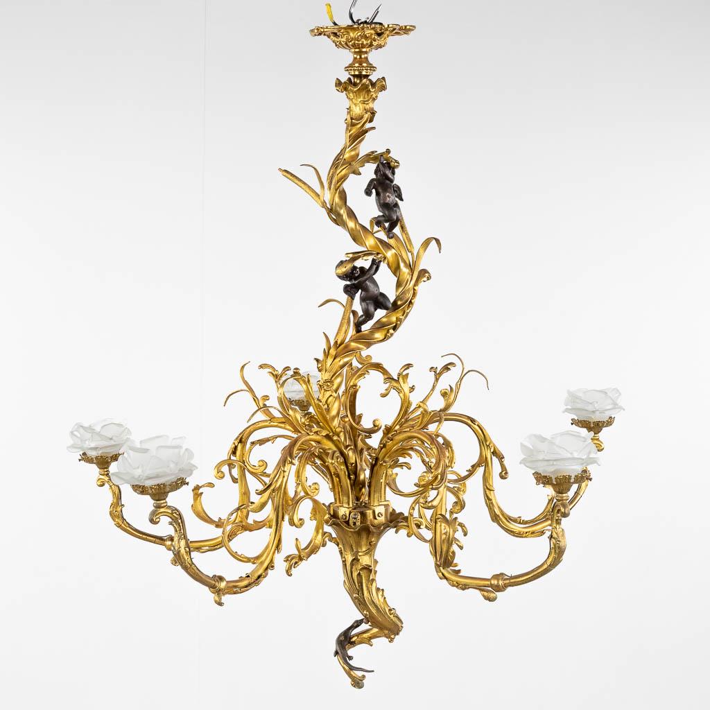 A large chandelier, gilt and patinated bronze in Louis XV style and decorated with putti and a (1 of 11)