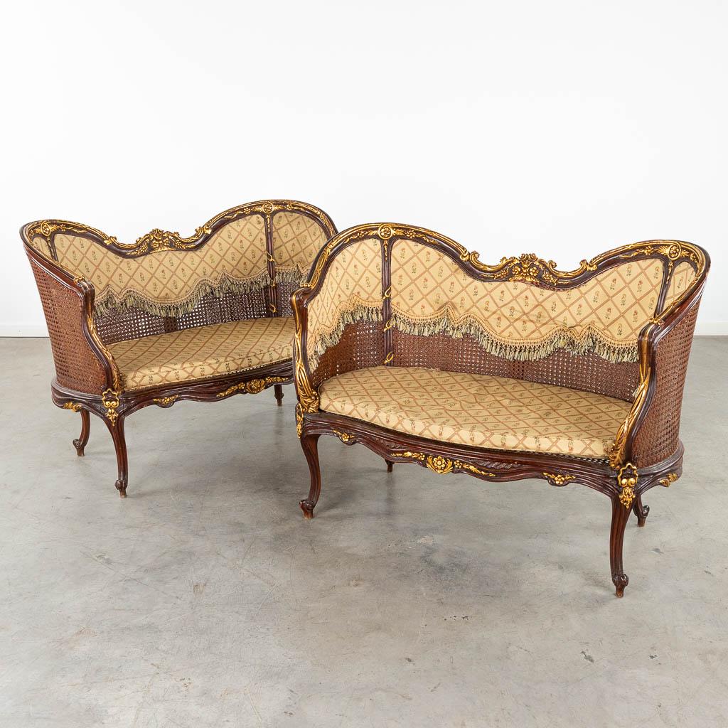 A pair of settee's, sculptured wood in Louis XV style and finished with caning. (D:62 x W:115 x H:84: A pair of settee's, sculptured wood in Louis XV style and finished with caning. Dimensions: (D:62 x W:115 x H:84 cm) Condition: Generally in good and solid condition. The caning in one of th