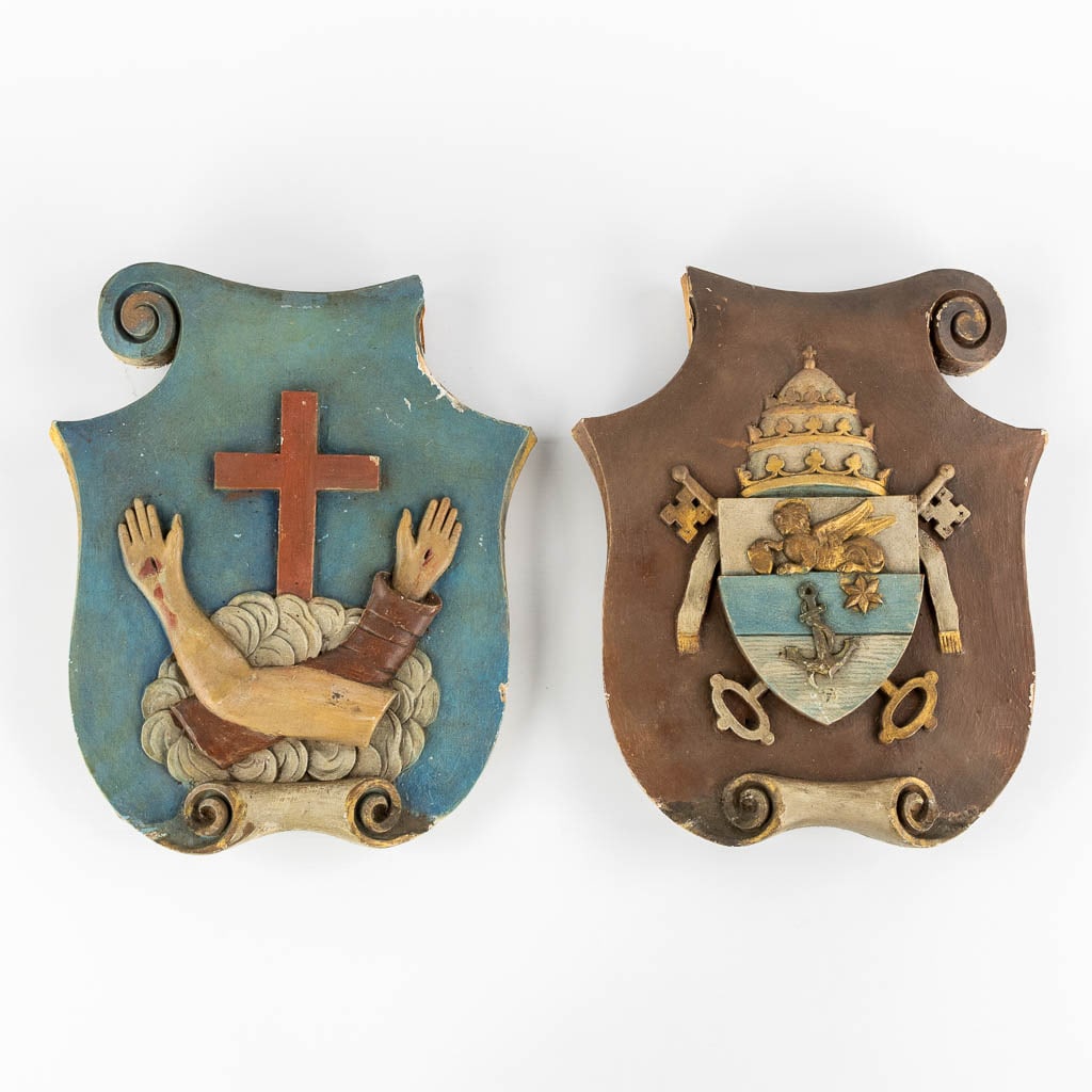 A pair of wood-sculptured coat of arms with Papal & Franciscan heraldry. (W:27 x H:32 cm): A pair of wood-sculptured coat of arms with Papal & Franciscan heraldry. One panel is the coat of arms for Pope Pius X. The other coat of arms for the 'Franciscans'. Condition report: - missin
