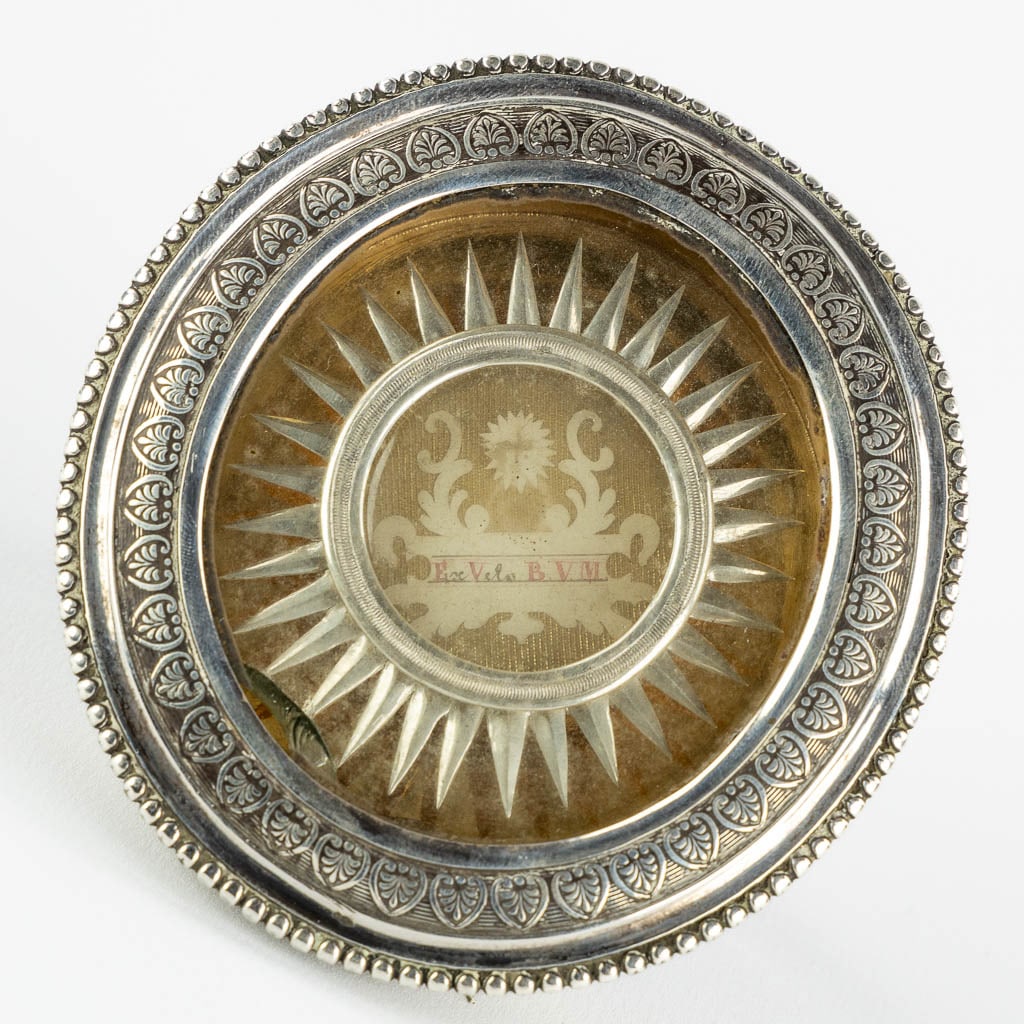 A sealed theca in a relic holder, 'Ex Velo B.M.V.' with a silver rim. Marked. 19th C. (W:9 x H:10 (1 of 6)