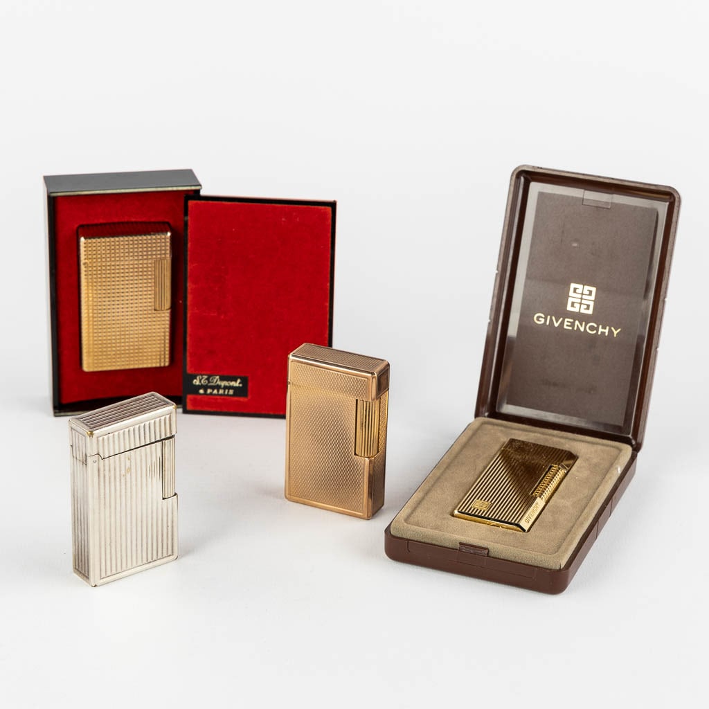 ST. Dupont, Three gold and silver plated lighters, added a Givency lighter. (L:1 x W:3,5 x H:6 cm) (1 of 14)