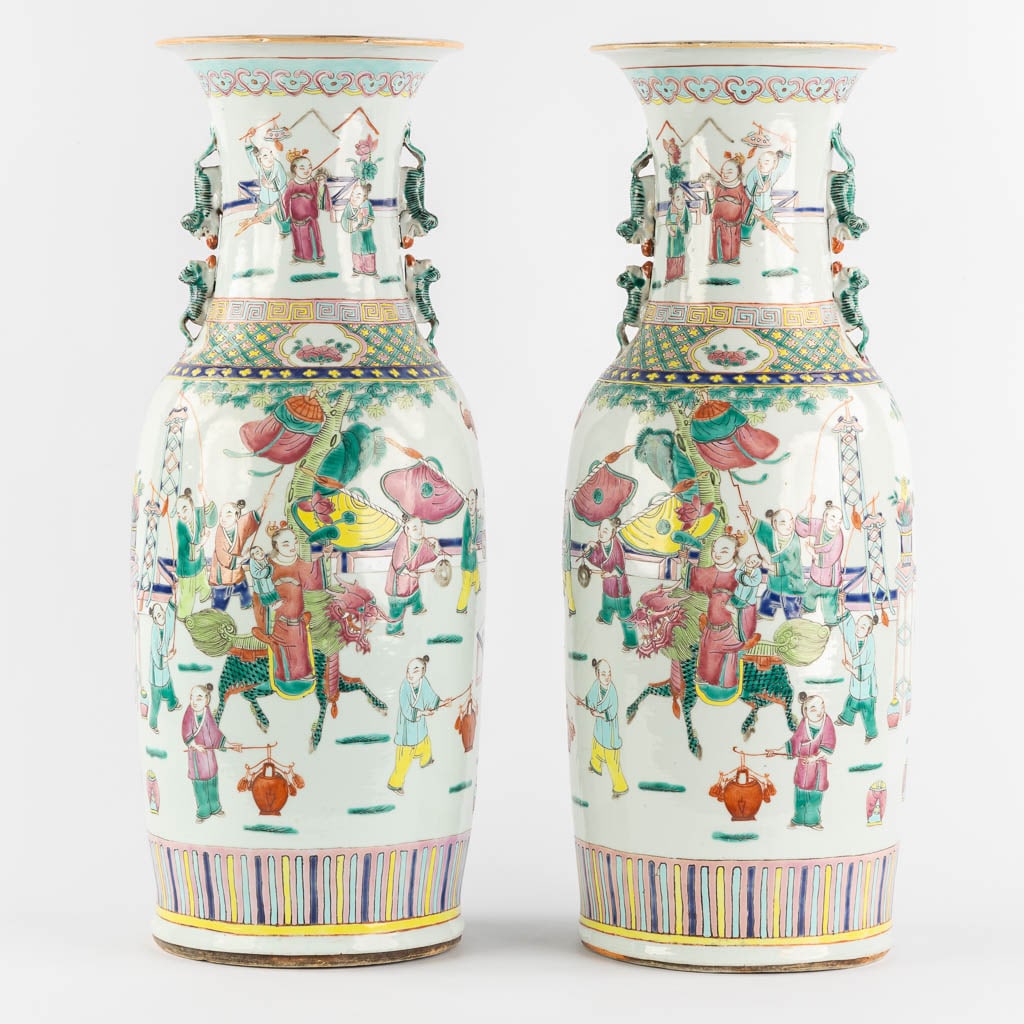 A pair of Chinese Famille Rose vases, Parade with dragons. (H:60 x D:23 cm): A pair of Chinese Famille Rose vases, Parade with dragons. Condition report: - One of the vases with a small chip on the upper rim, starting from a baking flaw. Otherwise in good condition. Dime