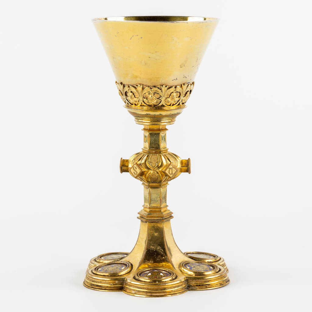 A Chalice, gilt brass mounted with enamelled medallions, Gothic Revival. (H:21,5 x D:13 cm): A Chalice, gilt brass mounted with enamelled medallions, Gothic Revival. Six medallions with images of the four evangelists in their tetramorph, Christ and The Virgin Mary with a 'Sacred Heart'